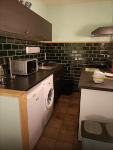 维尔雅尔姆Forest 104的厨房配有洗衣机和微波炉。