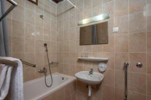 克拉列维察Uvala Scott的浴室配有水槽、淋浴、浴缸和镜子