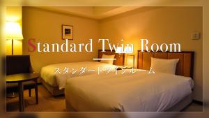 筑波筑波日航都市酒店(Hotel JAL City Tsukuba)的酒店客房设有两张床,标有阅读标准双床间的标志。