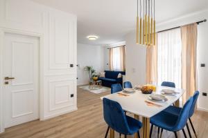 特罗吉尔VIPo Seget Apartments的一间配备有白色桌子和蓝色椅子的用餐室