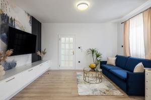 特罗吉尔VIPo Seget Apartments的客厅配有蓝色的沙发和电视