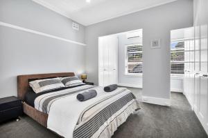 悉尼Stylish, Sunny & Spacious 2 Bedroom Apartment, Mosman的一间卧室配有一张带两个枕头的床