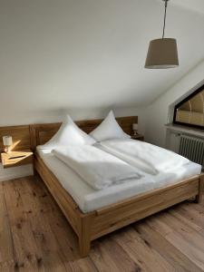 埃恩鲁赫Haus Cornelia的一张带白色床单和枕头的床