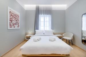 希俄斯Giustiniani Apartments的卧室配有白色的床和2条毛巾