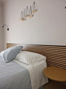 莱斯卡拉Pensió i Apartament Torrent的一间卧室配有一张带木制床头板和一张桌子的床。