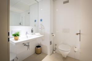贝尔普Los Lorentes Hotel Bern Airport的白色的浴室设有卫生间和水槽。