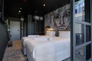 卢萨卡Cargo88 Hotel的一间卧室配有两张床,墙上挂着一幅画