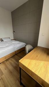 别尔斯克-比亚拉CityCenterApartments/M32/8B的卧室配有1张床、1张桌子和1把椅子