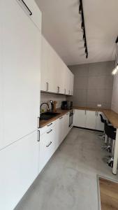 别尔斯克-比亚拉CityCenterApartments/M32/8B的一间大厨房,配有白色的橱柜和水槽