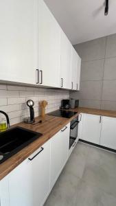 别尔斯克-比亚拉CityCenterApartments/M32/8B的厨房配有白色橱柜和木制台面