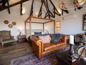 奥奇瓦龙戈Otjiwa Mountain Lodge的一间卧室配有真皮沙发和一张床