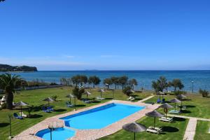 罗达S&C Kosmos Beach Resort的毗邻大海的带椅子和遮阳伞的游泳池