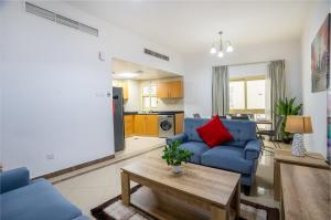迪拜RH- Experience Comfort and Convenience in our 2BR, Al Barsha的客厅配有蓝色的沙发和桌子
