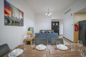 迪拜RH- Experience Comfort and Convenience in our 2BR, Al Barsha的一间带桌子和蓝色沙发的用餐室