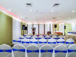 沙迦Zenith Smart Vacation Homes, Sharjah的一间会议室,配有白色椅子和讲台