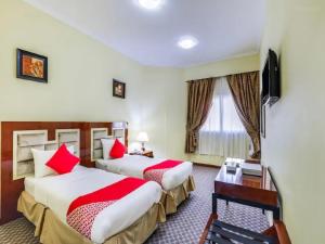 沙迦Zenith Smart Vacation Homes, Sharjah的两张位于酒店客房的床铺,配有红色枕头