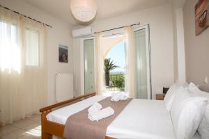 罗达S&C Kosmos Beach Resort的一间卧室配有带毛巾的床