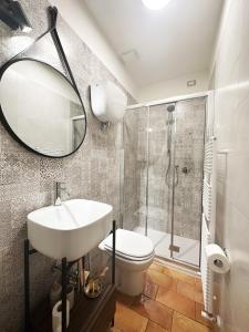 阿西西歌曲客房旅馆的浴室配有盥洗池、卫生间和镜子。