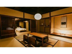 TatsunoKominka Hotel kurasu - Vacation STAY 24260v的客厅配有桌子和床。