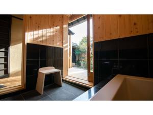TatsunoKominka Hotel kurasu - Vacation STAY 24260v的带浴缸和凳子的浴室