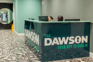 都柏林The Dawson Hostel的两人坐在一张桌子上,手提电脑