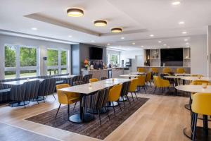 卡纳塔Microtel Inn & Suites by Wyndham Kanata Ottawa West的用餐室配有桌子和黄色椅子