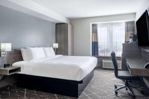 卡纳塔Microtel Inn & Suites by Wyndham Kanata Ottawa West的酒店客房配有一张床、一张书桌和一台电脑
