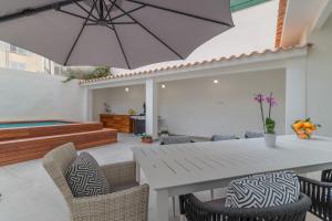 马略卡岛帕尔马Palma -2702 Mallorca的庭院配有白色的桌椅和遮阳伞。