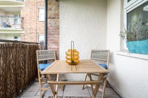 伍德福德格林Stylish flat In London for Tourists, Contractors, Relocators - sleeps 5的天井上配有一张木桌和两把椅子