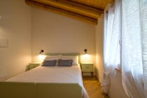 圣佩莱格里诺温泉Villa Mariolino的卧室配有白色的床和窗户。