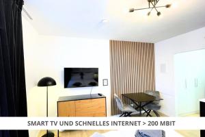 拜罗伊特Apartment Wahnfried No4 - Zentral wohnen mit Küche und Duschbad, Parkplatz, 300m zur Fussgängerzone的客厅配有电视和桌子