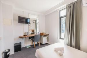 悉尼Newtown Cozy Stays的配有一张床和一张书桌的酒店客房