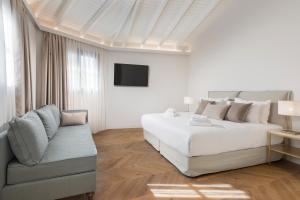 雅典The Residence Aiolou Hotel & Spa的白色卧室配有床和沙发