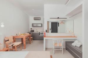 马克里亚罗斯Plakakia Luxury Apartments的厨房以及带桌椅的起居室。