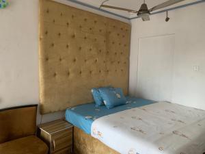 莱基New Travellers Lodge Sangotedo Lagos的一间小卧室,配有一张床和一把椅子