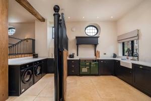 BrillPass the Keys Merlin’s stables-country retreat的厨房配有黑色橱柜和绿色烤箱