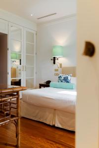 马尔米堡卡莉福尼亚花园酒店的一间卧室配有一张床、一张桌子和一张桌子