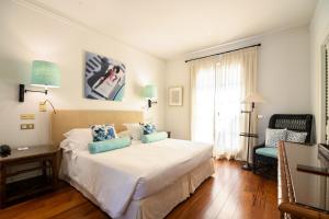 马尔米堡卡莉福尼亚花园酒店的卧室配有带蓝色枕头的大型白色床