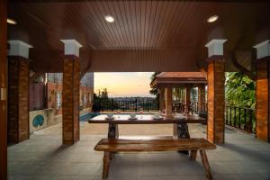 芭东海滩私人泳池 芭东海景 绝美落日 四卧别墅的阳台上的木桌和长凳