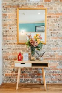 悉尼Newtown Cozy Stays的一张桌子,上面有镜子和花瓶