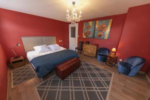 凯泽贝尔Origin'alsace的卧室设有红色的墙壁和一张床及椅子