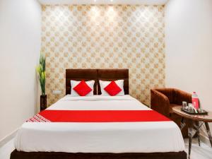 卢迪亚纳OYO Flagship Golden A的一间卧室配有一张带红色枕头的床和一张桌子