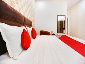 卢迪亚纳OYO Flagship Golden A的一间卧室配有红色和白色枕头的床