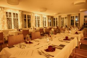 阿伦斯霍普Der Charlottenhof的餐厅配有白色的桌椅和圣诞灯