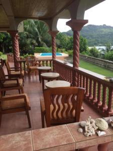 马埃岛Bayview Villa -Sea Side Villa的一个带桌椅的门廊和一个游泳池