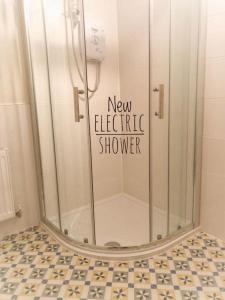 莫维尔Moville Beach Townhouse on Wild Atlantic Way的浴室设有淋浴和新的电热淋浴