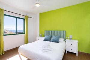 圣胡安海滩Nice 2 bd apartment by the sea in Playa San Juan的绿色卧室设有床和窗户