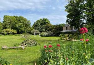 奇切斯特A Unique, Rural, Modern Annexe with Large Garden, Games, Tennis Court & EV Point的鲜花盛开的花园,后方的房子