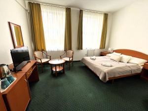 布达佩斯Broadway City Guesthouse的配有一张床和一台平面电视的酒店客房