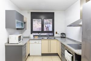 奥尔迪诺AndBnB I 3 Habitaciones con Terraza y Parking的白色的厨房配有水槽和微波炉